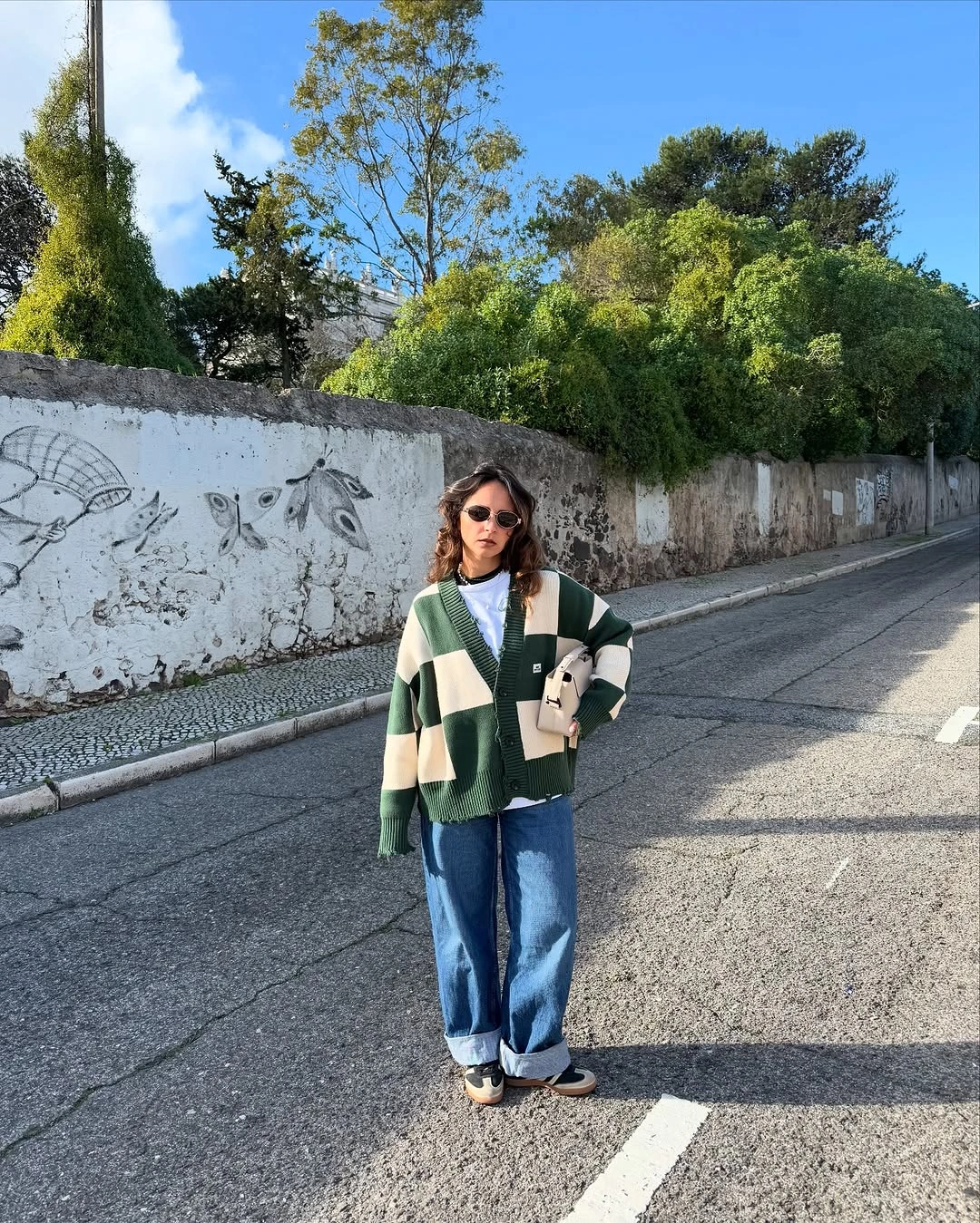 Green and cream geometric sweater with straight blue jeans