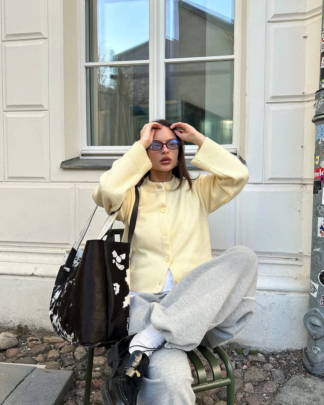 Pale yellow overshirt with gray wide-leg trousers and black tote