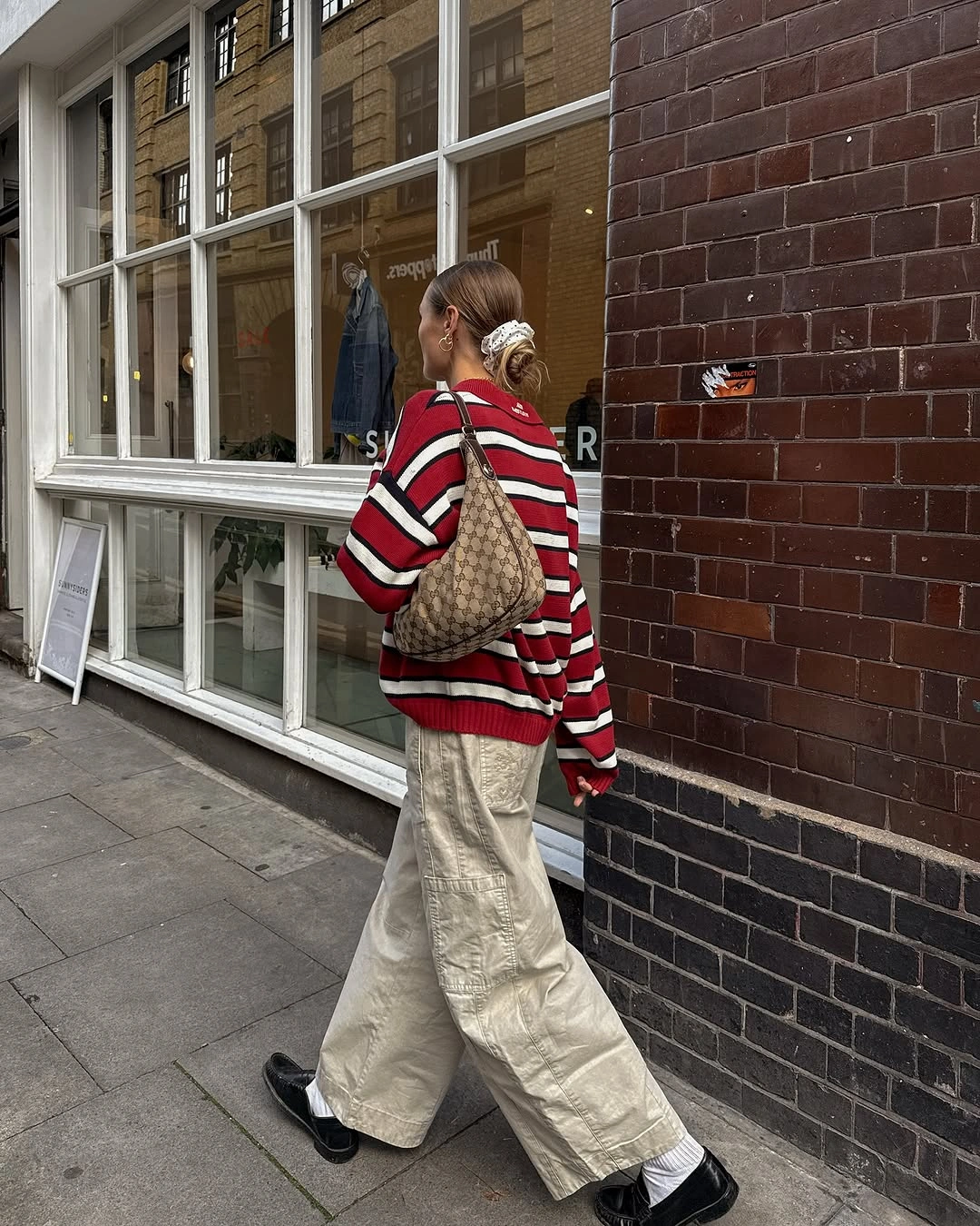Red striped sweater with cream wide-leg trousers and dark shoes