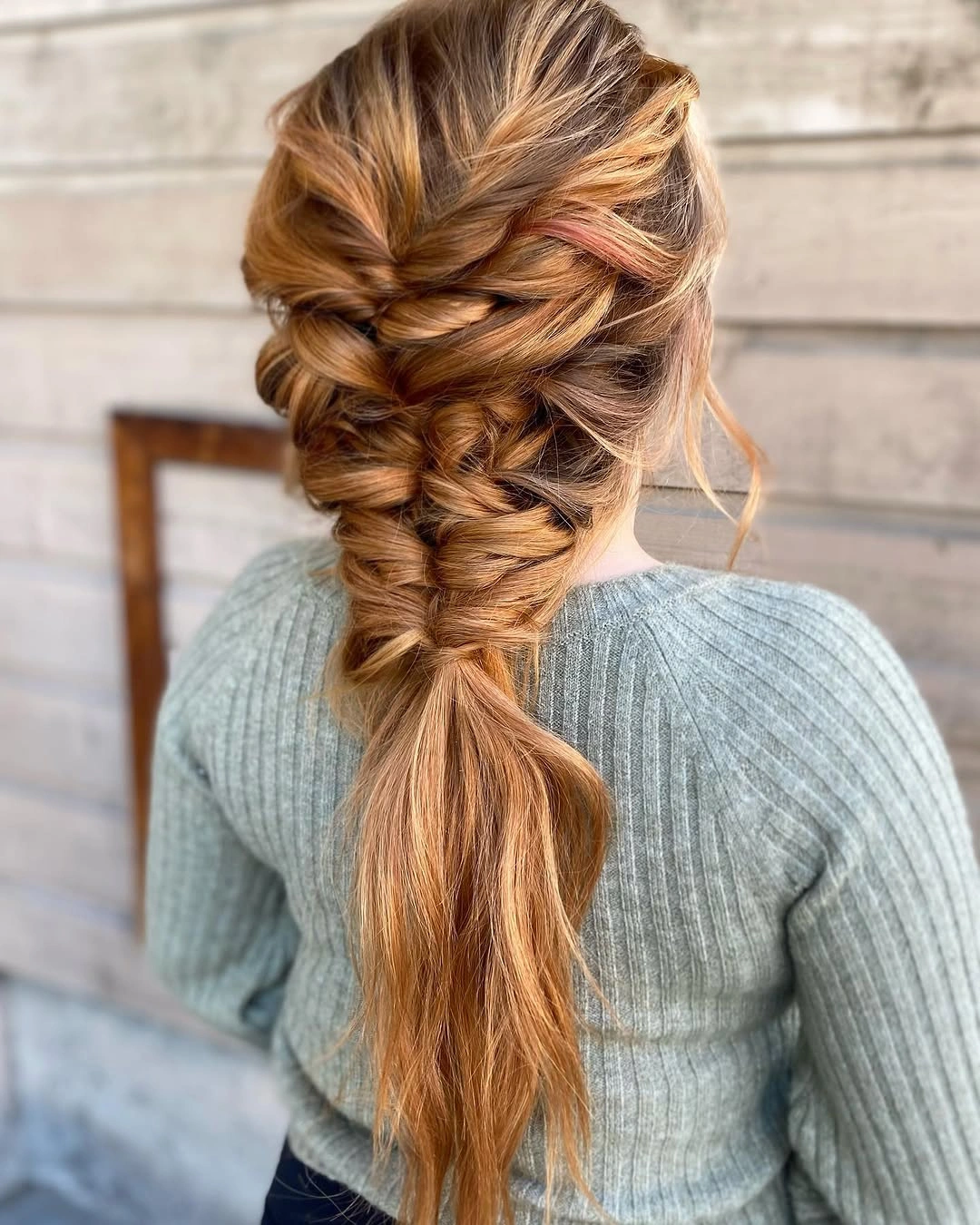 Long copper hair braided into a thick back plait