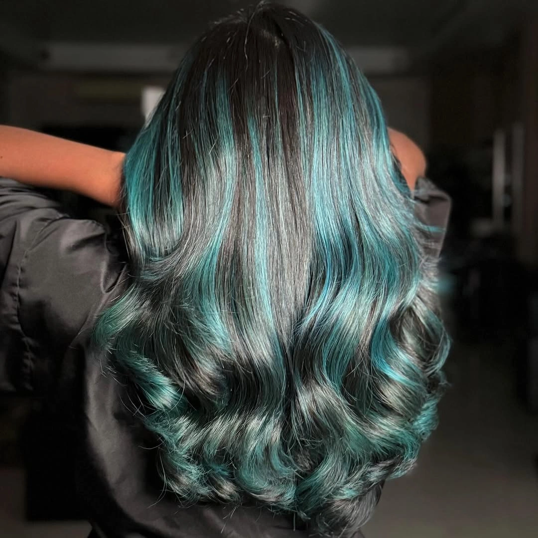 Long black hair with vivid teal color through lower waves