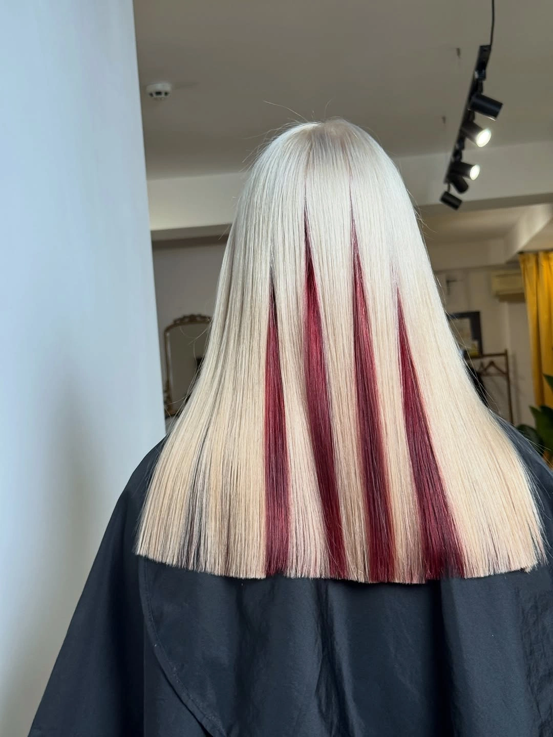 Straight platinum hair with narrow burgundy vertical panels