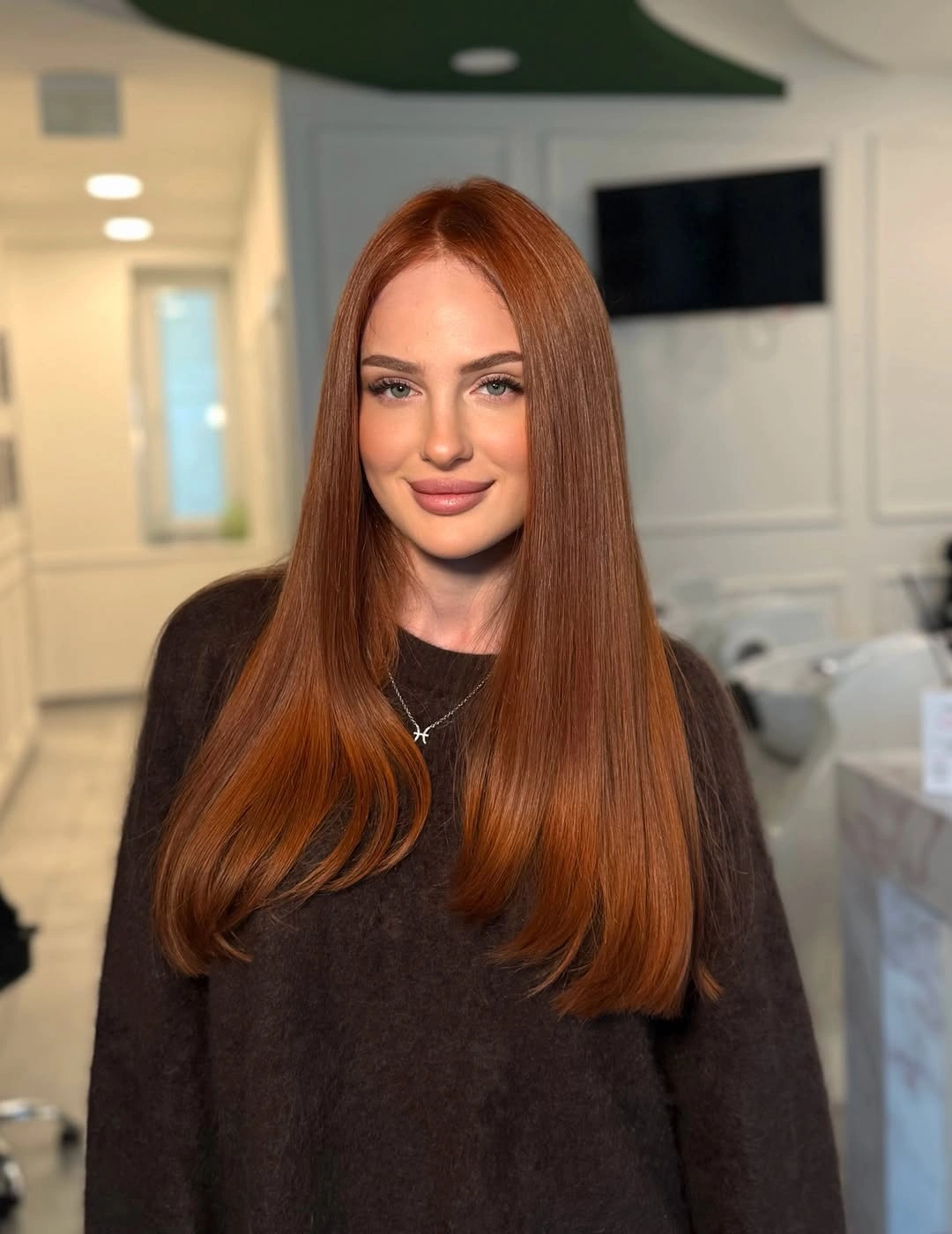 Long copper red hair with center part and smooth ends