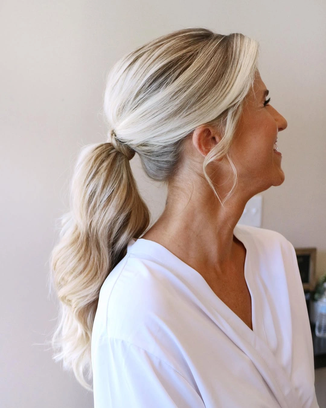 Platinum blonde low ponytail with loose face pieces