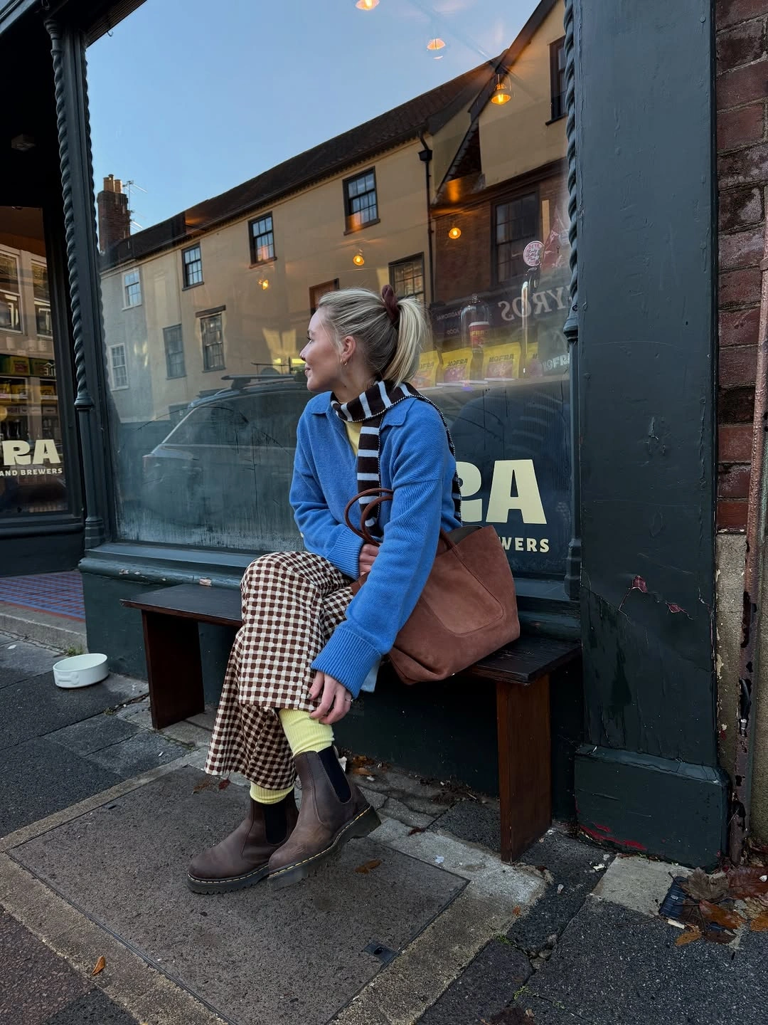 Blue zip jacket with checked skirt and dark boots