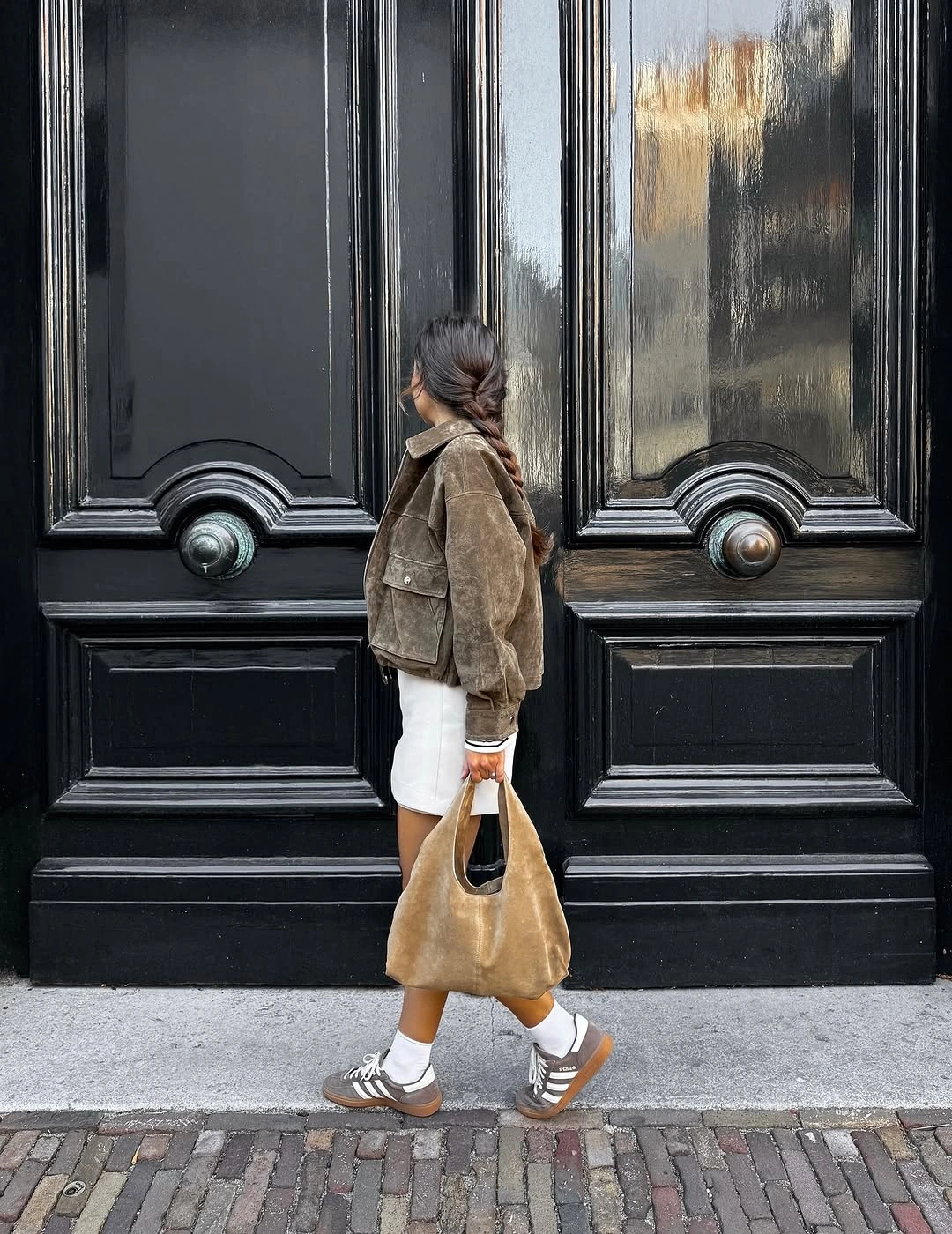 Taupe jacket over white shorts with tan shoulder bag