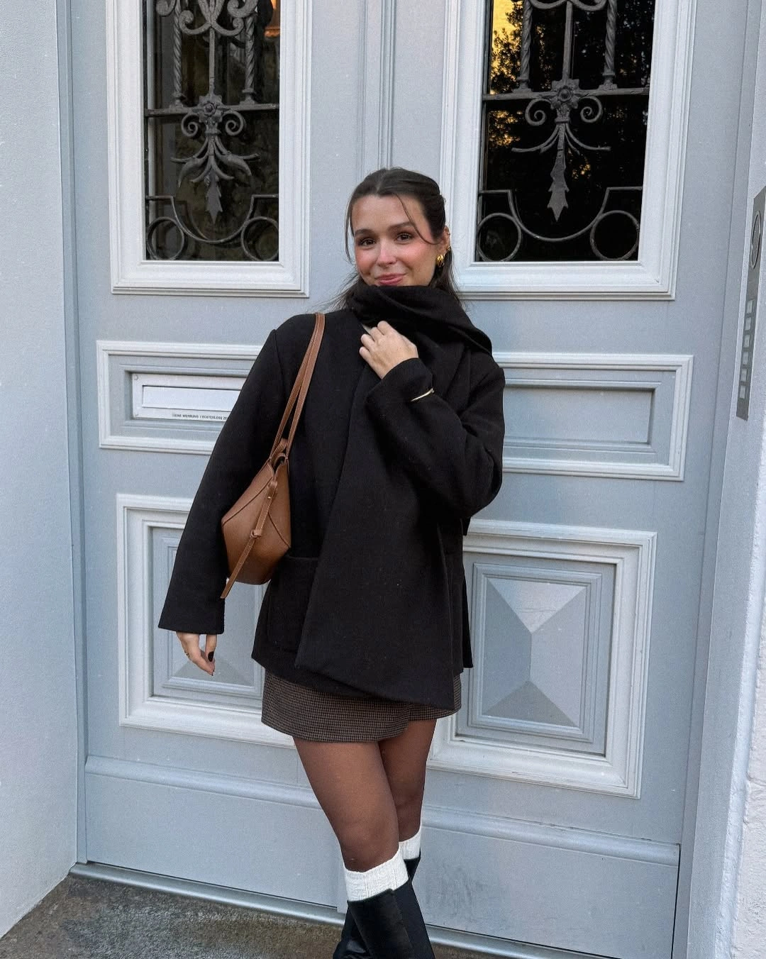 Oversized black sweatshirt with gray mini skirt and pale socks