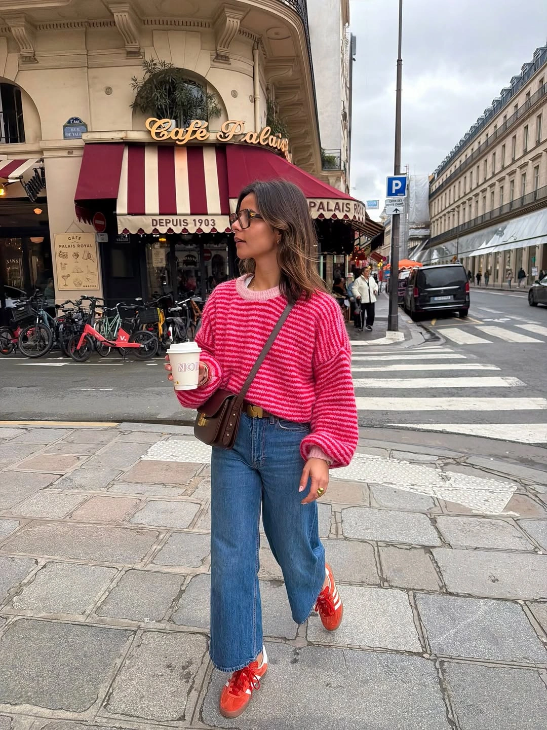 Bright pink striped sweater with blue jeans and red sneakers