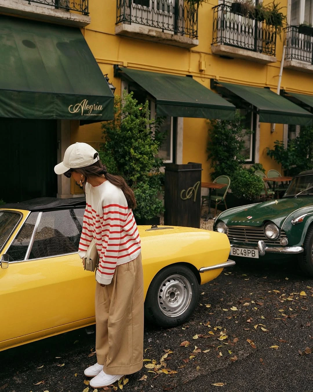 Red striped sweater with beige trousers pale cap and light shoes