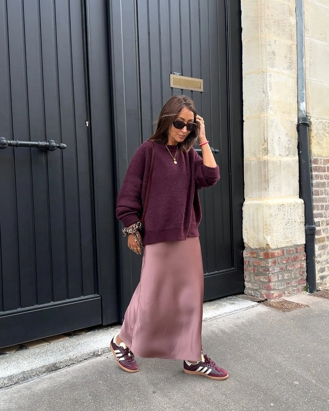 Burgundy sweater with blush pink satin midi skirt and sneakers