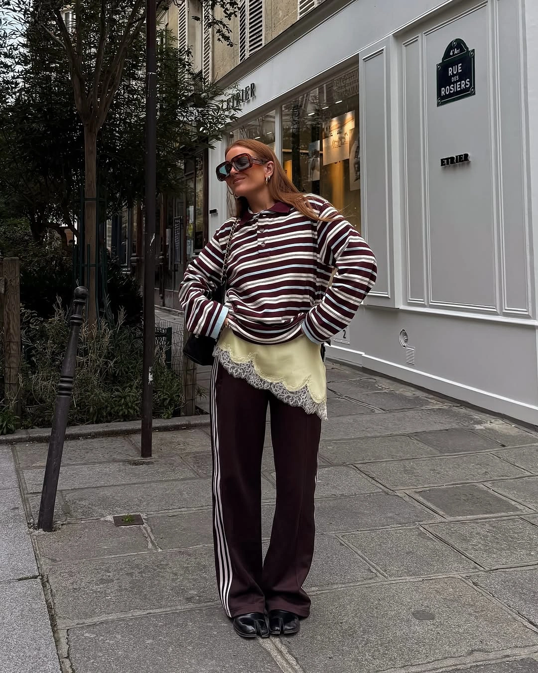 Striped sweater layered over lace hem with wide dark trousers