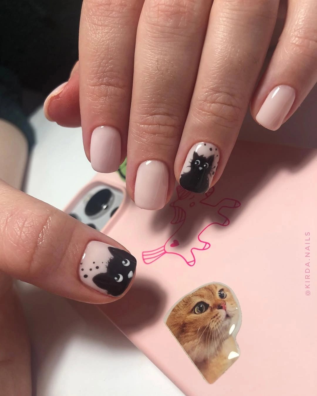 Short blush square nails with tiny black and white character accents