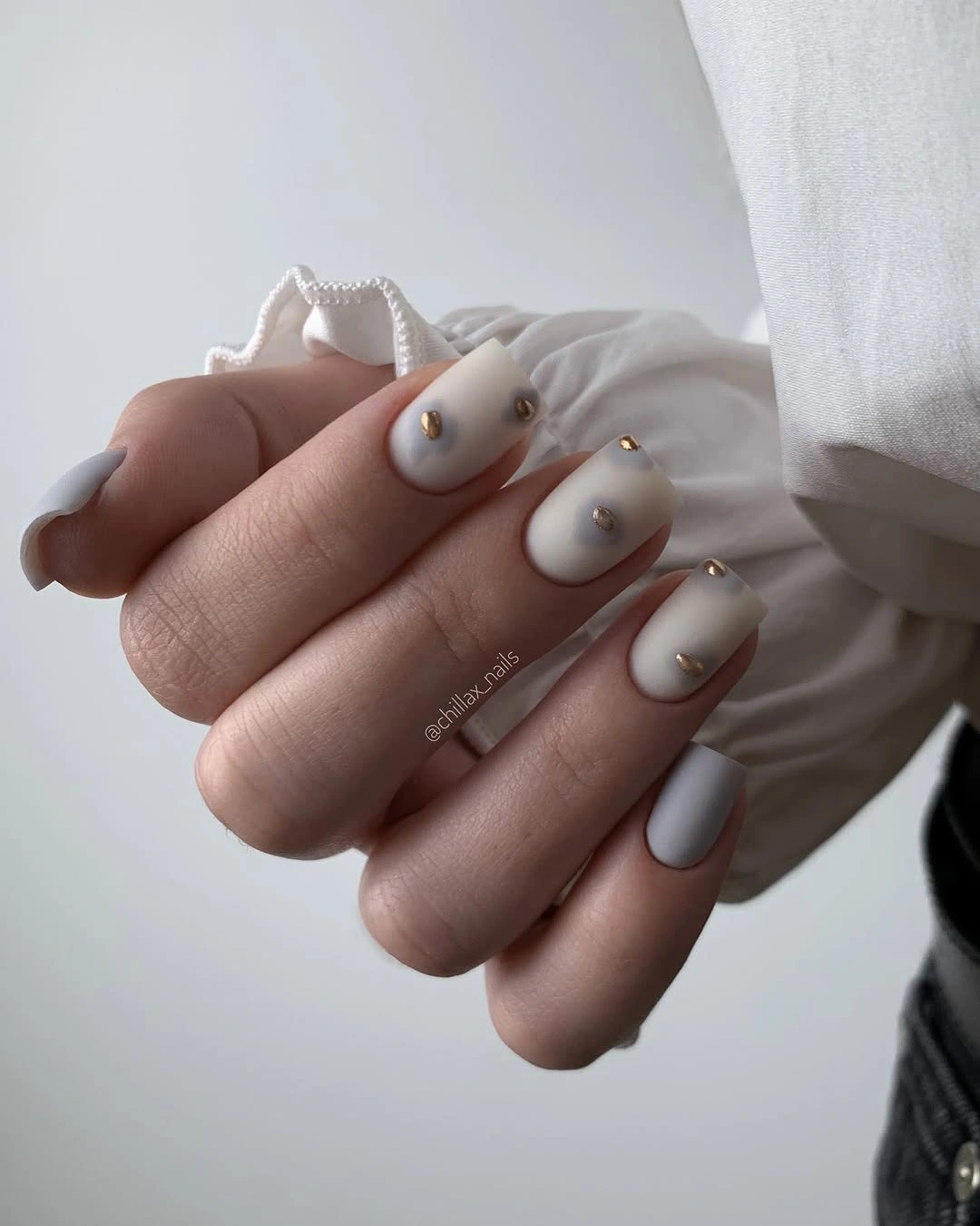 Short milky white nails with small gold cuticle studs