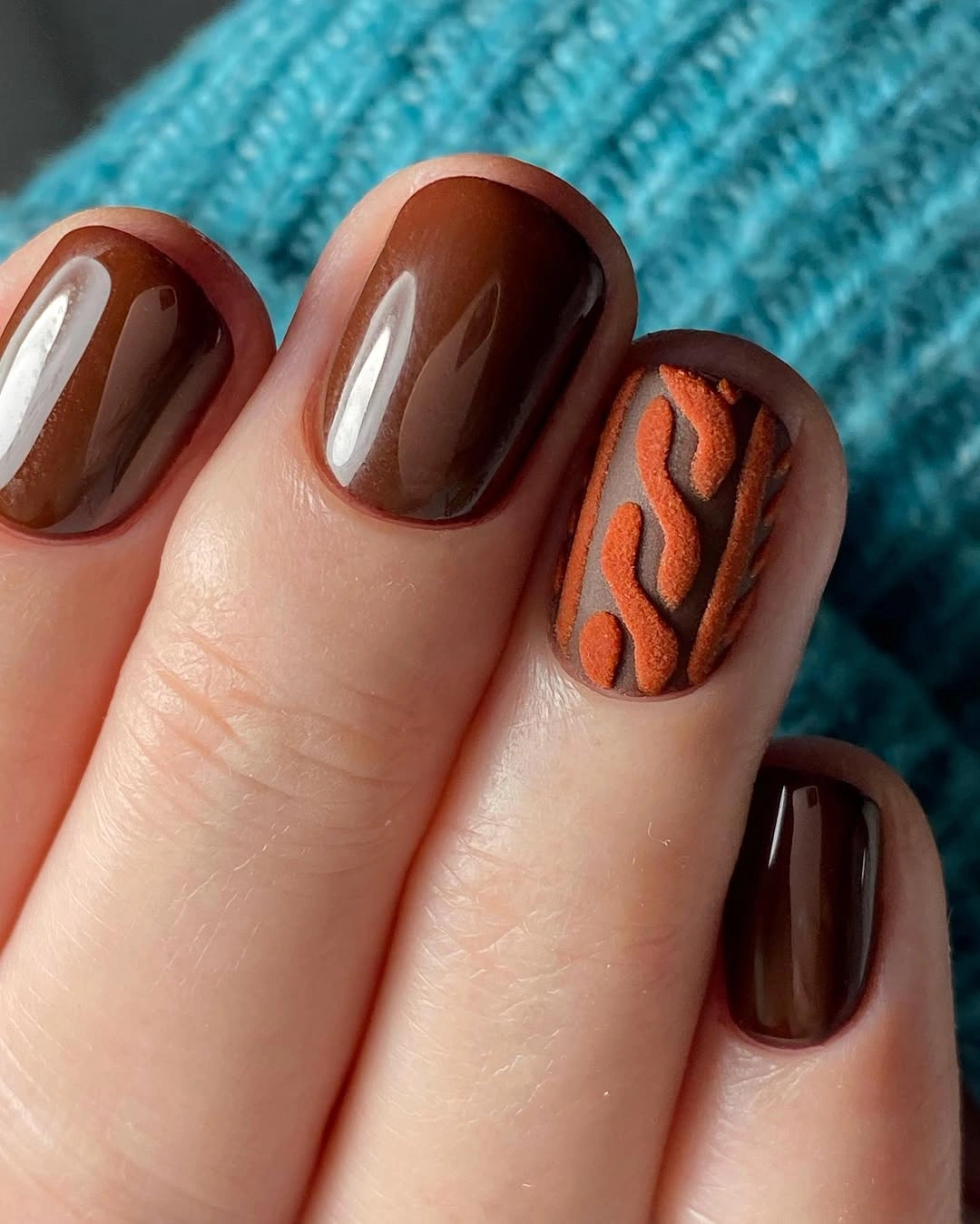 Short brown nails with a burnt orange textured accent