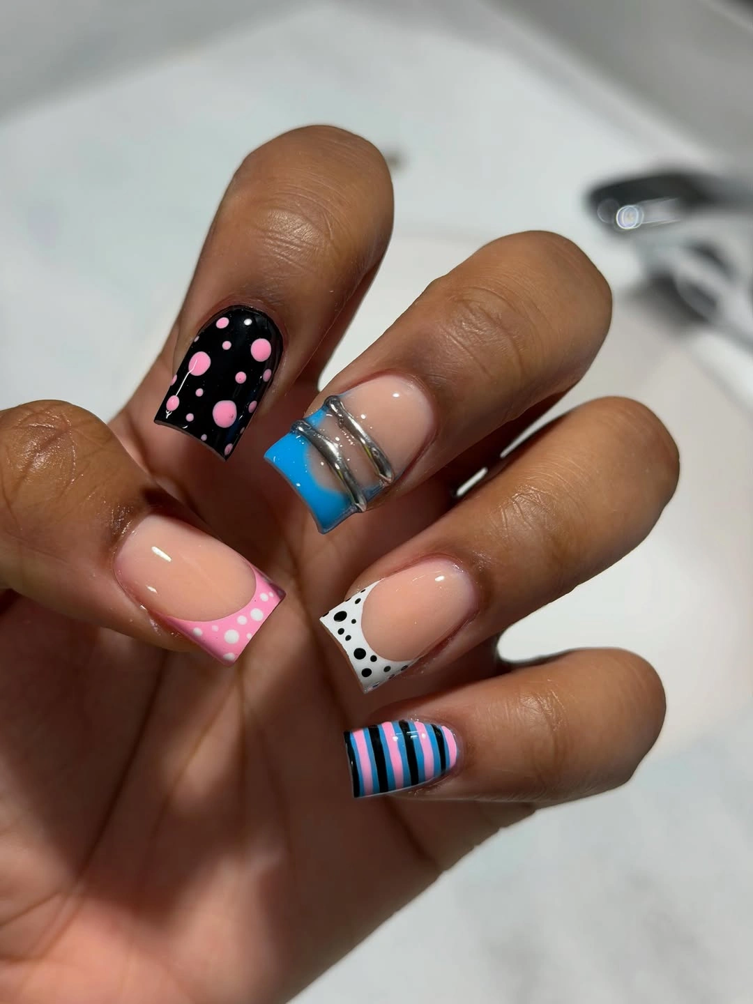 Short square nails with pink blue white and striped tips