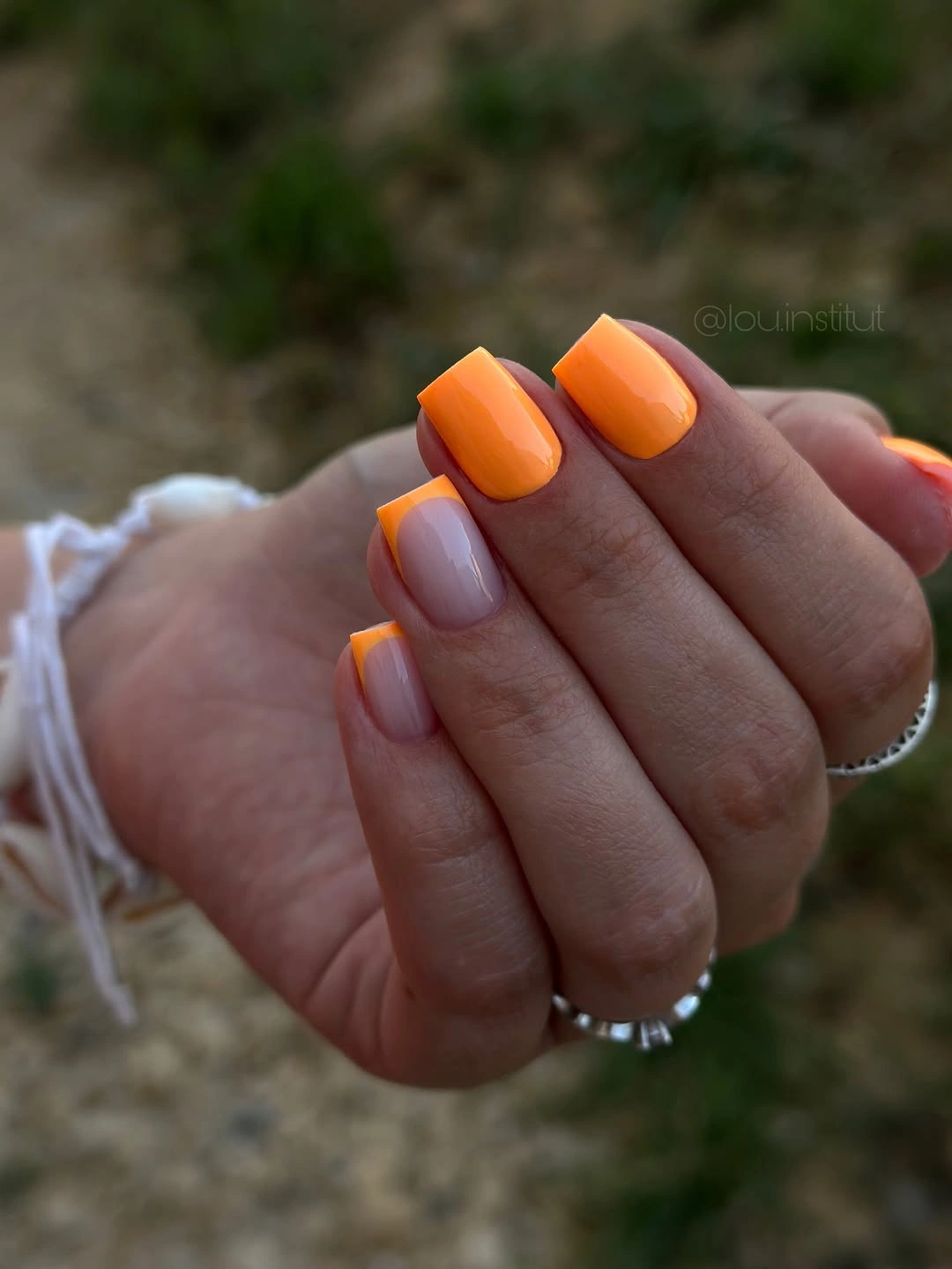 Short nude square nails with vivid orange French tips