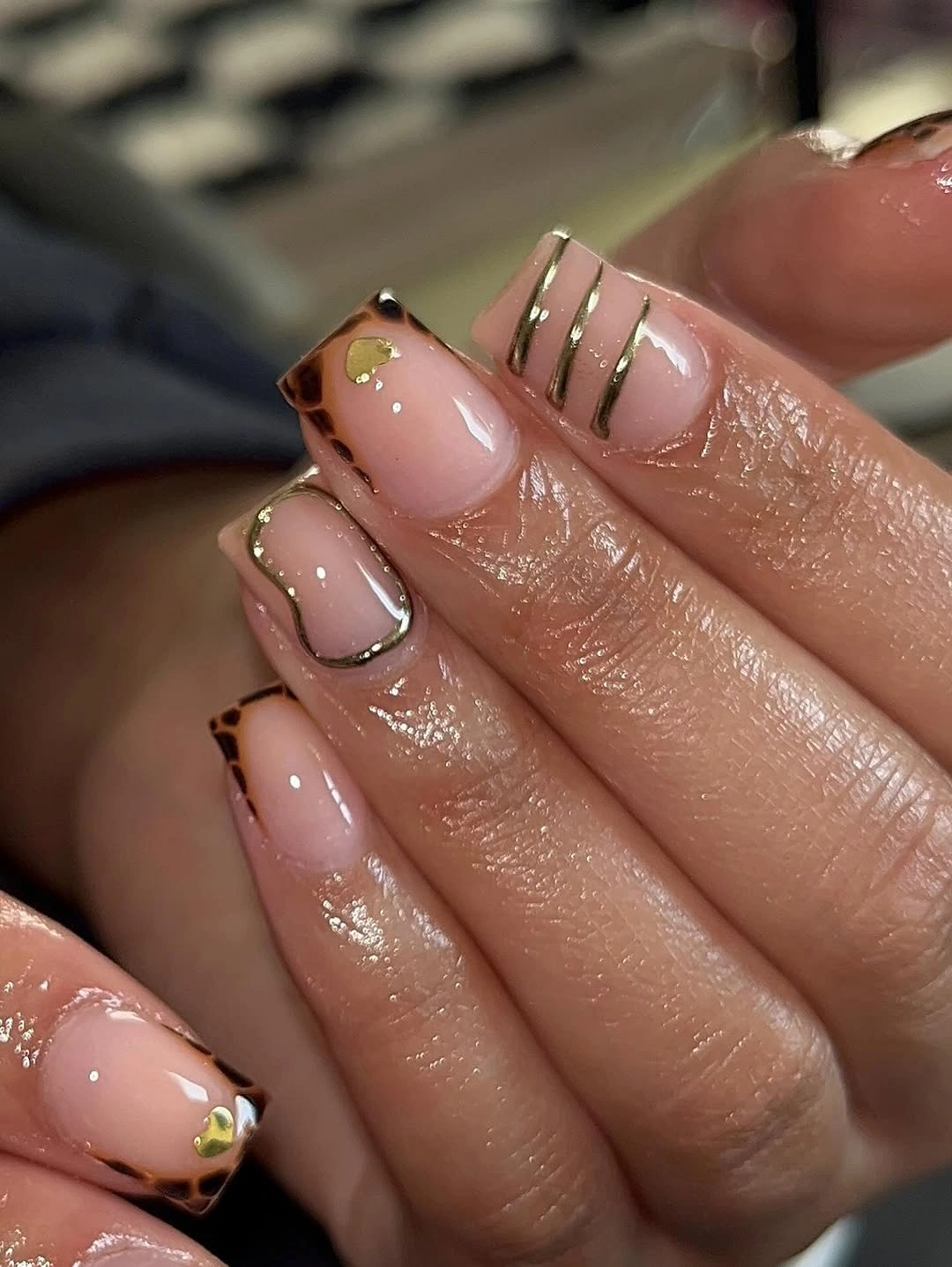 Short blush square nails with tortoiseshell corners and gold lines