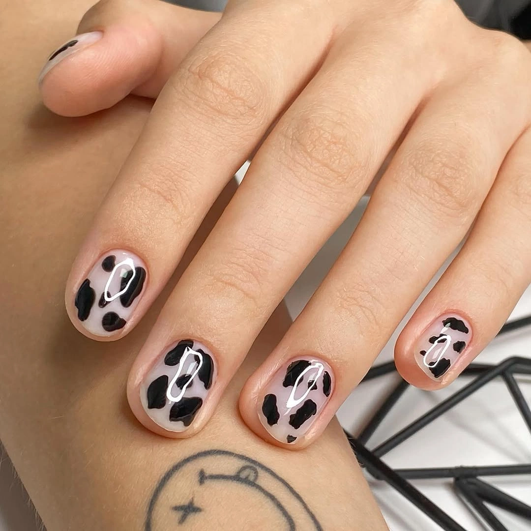 Short nude pink nails with irregular black and white spots