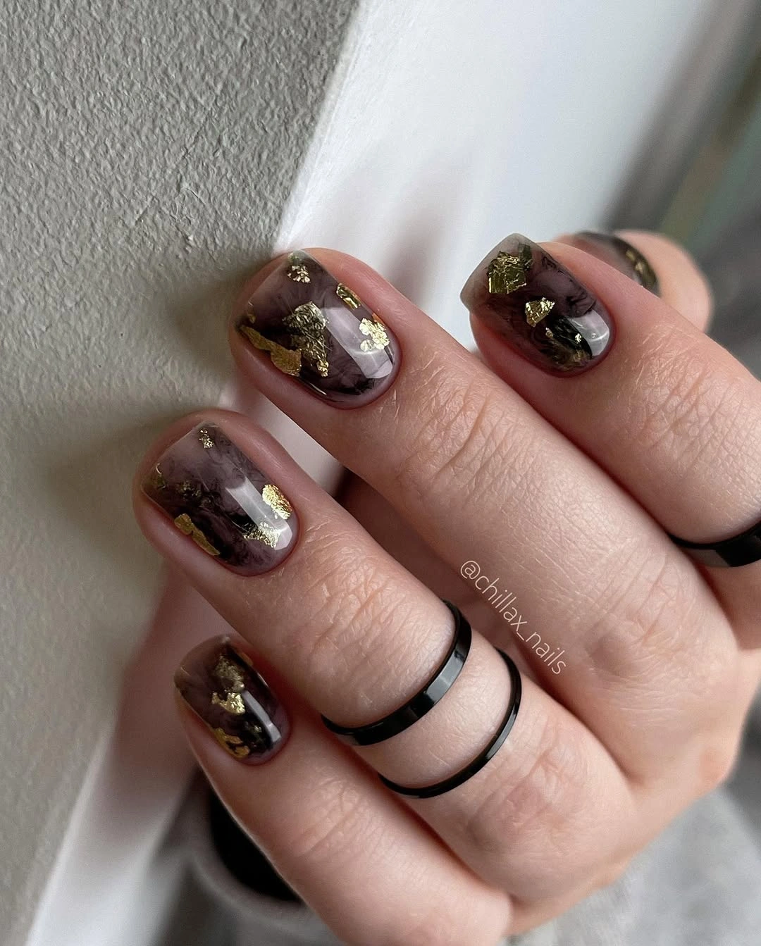 Short smoky mauve nails with irregular gold foil accents