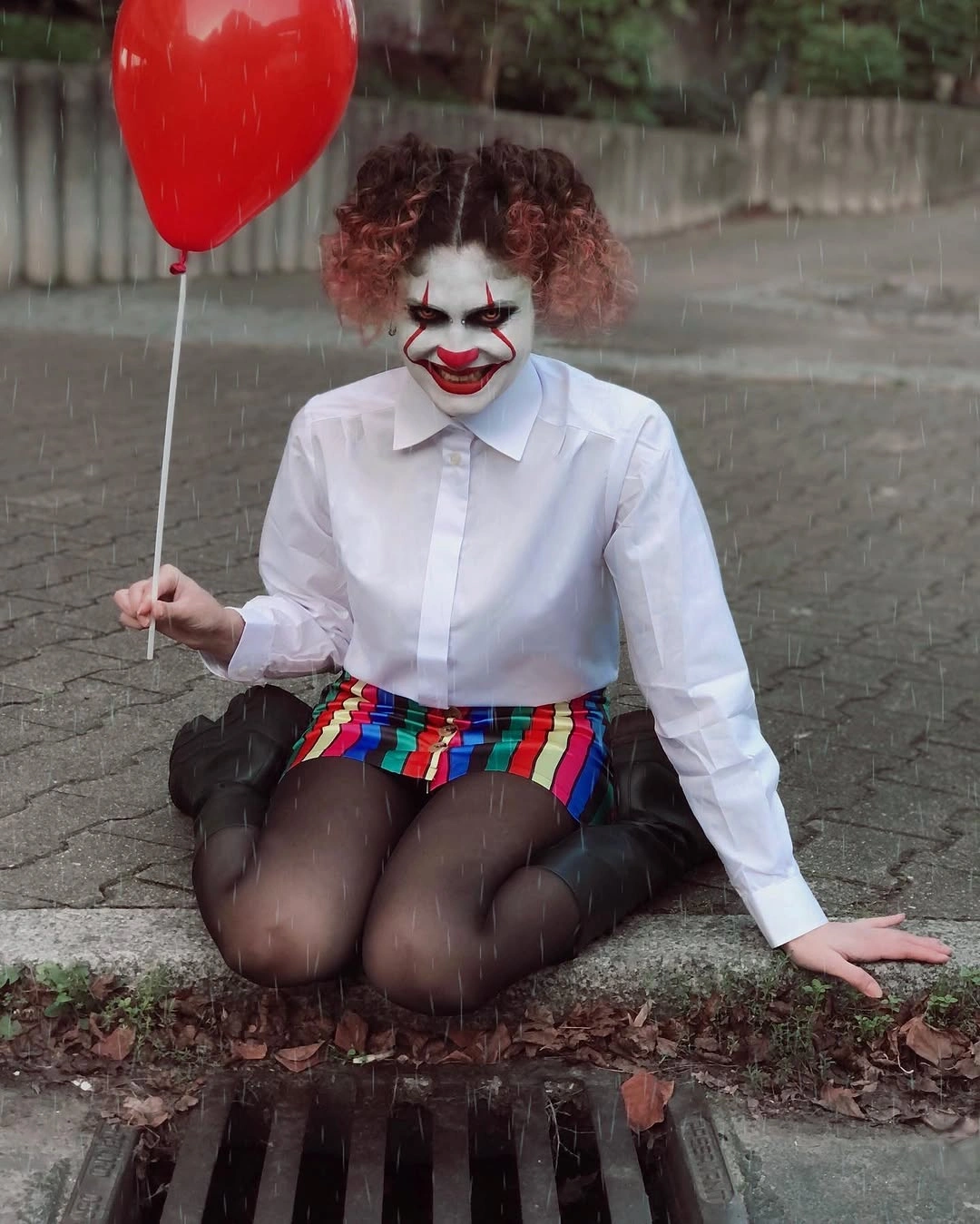 Pennywise from It costume with white shirt, clown makeup, and red balloon