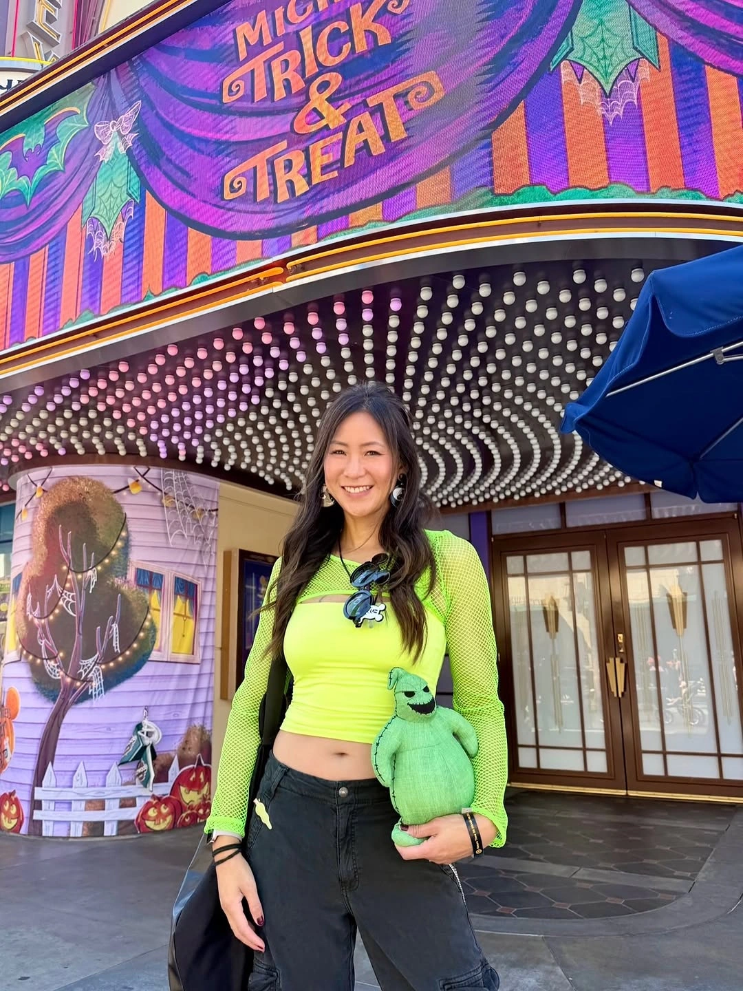 Kim Possible costume with neon green top, black cargo pants, and green sidekick