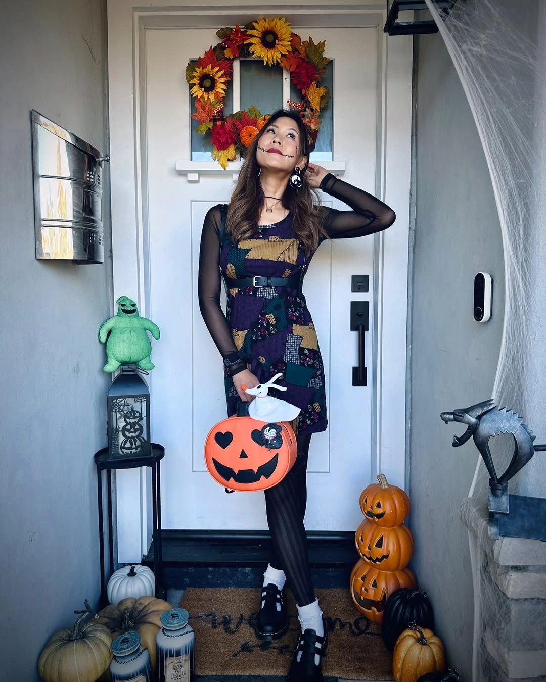 Sally costume with patchwork dress, red hair, stitched makeup, and dark sleeves