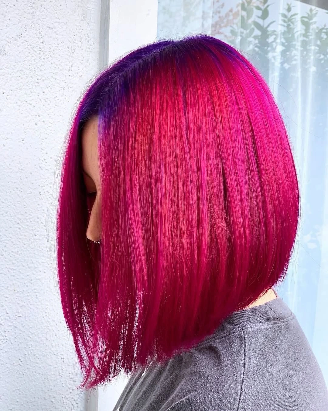 Vivid magenta angled bob with darker root and rounded back