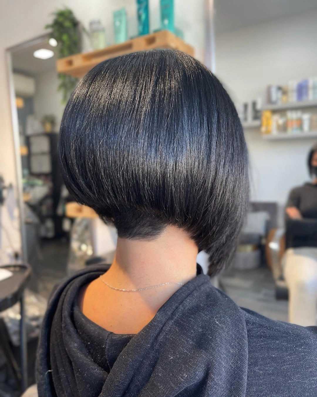 Glossy black stacked bob with rounded back and tucked nape