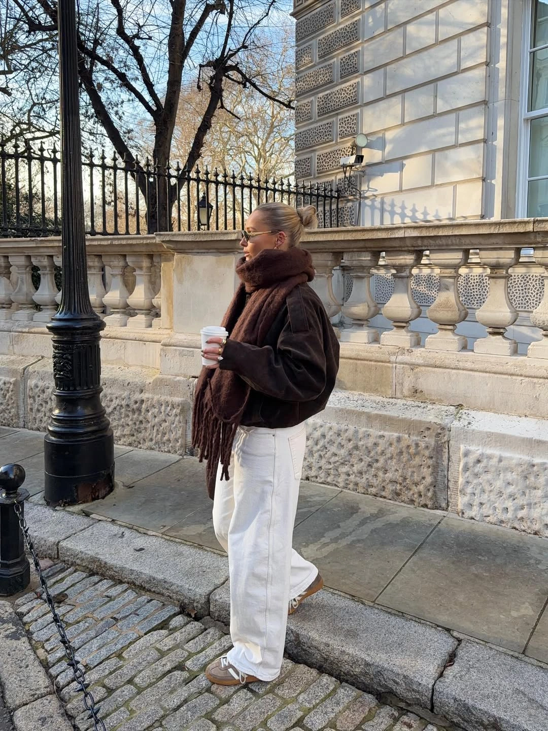 Dark brown jacket and scarf with wide white trousers and tan sneakers