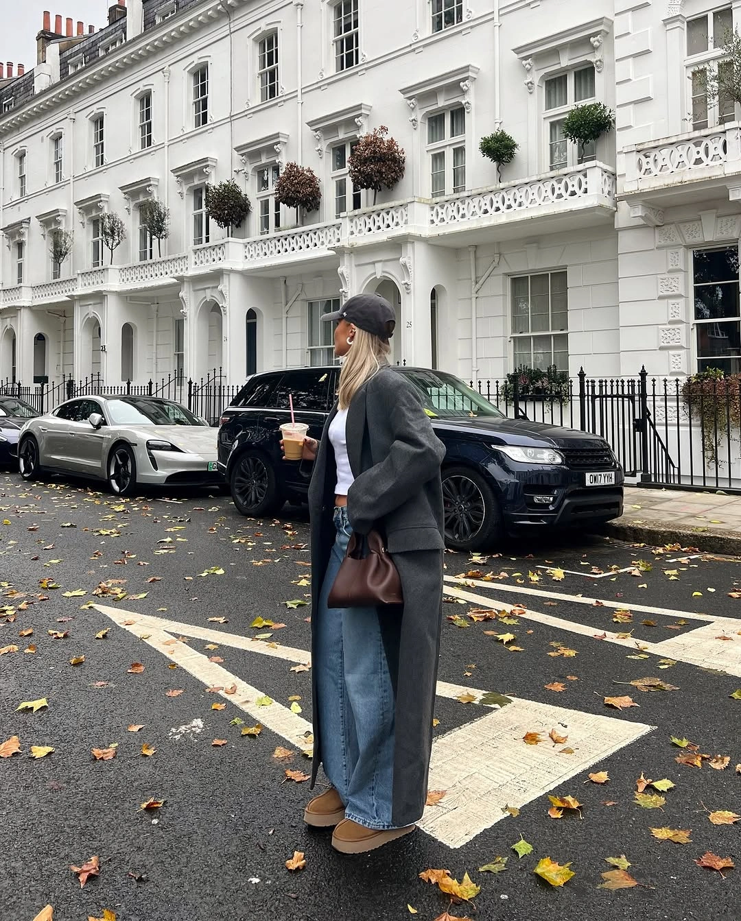 Long gray coat with wide blue jeans and tan platform shoes