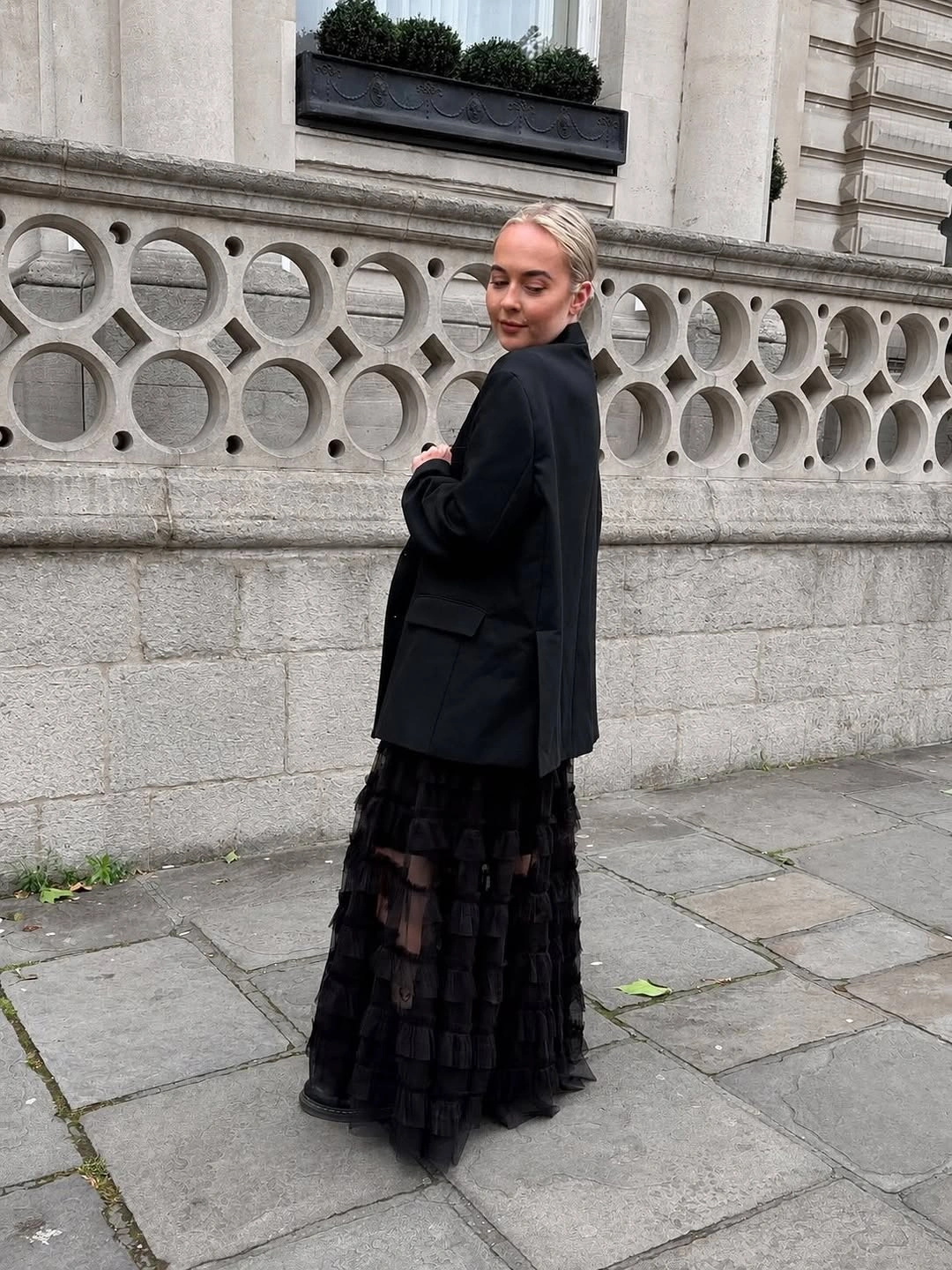 Black blazer with floor-length textured skirt and dark footwear