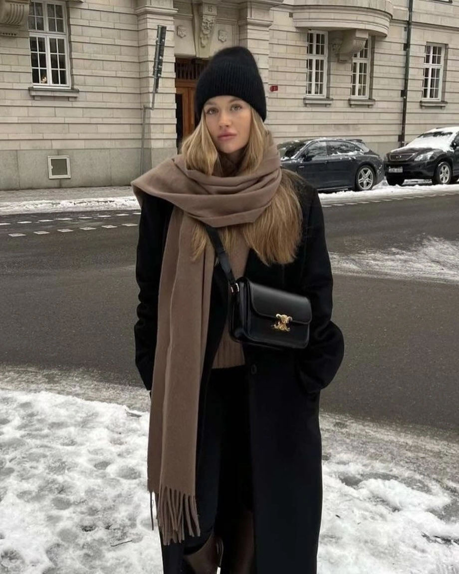 Black coat and beanie with oversized taupe-brown wrapped scarf