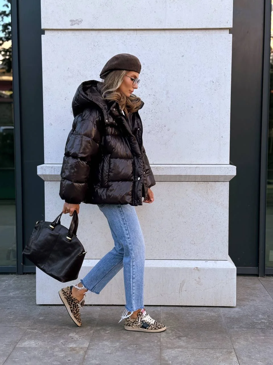 Glossy black jacket with cropped jeans and leopard-pattern low shoes