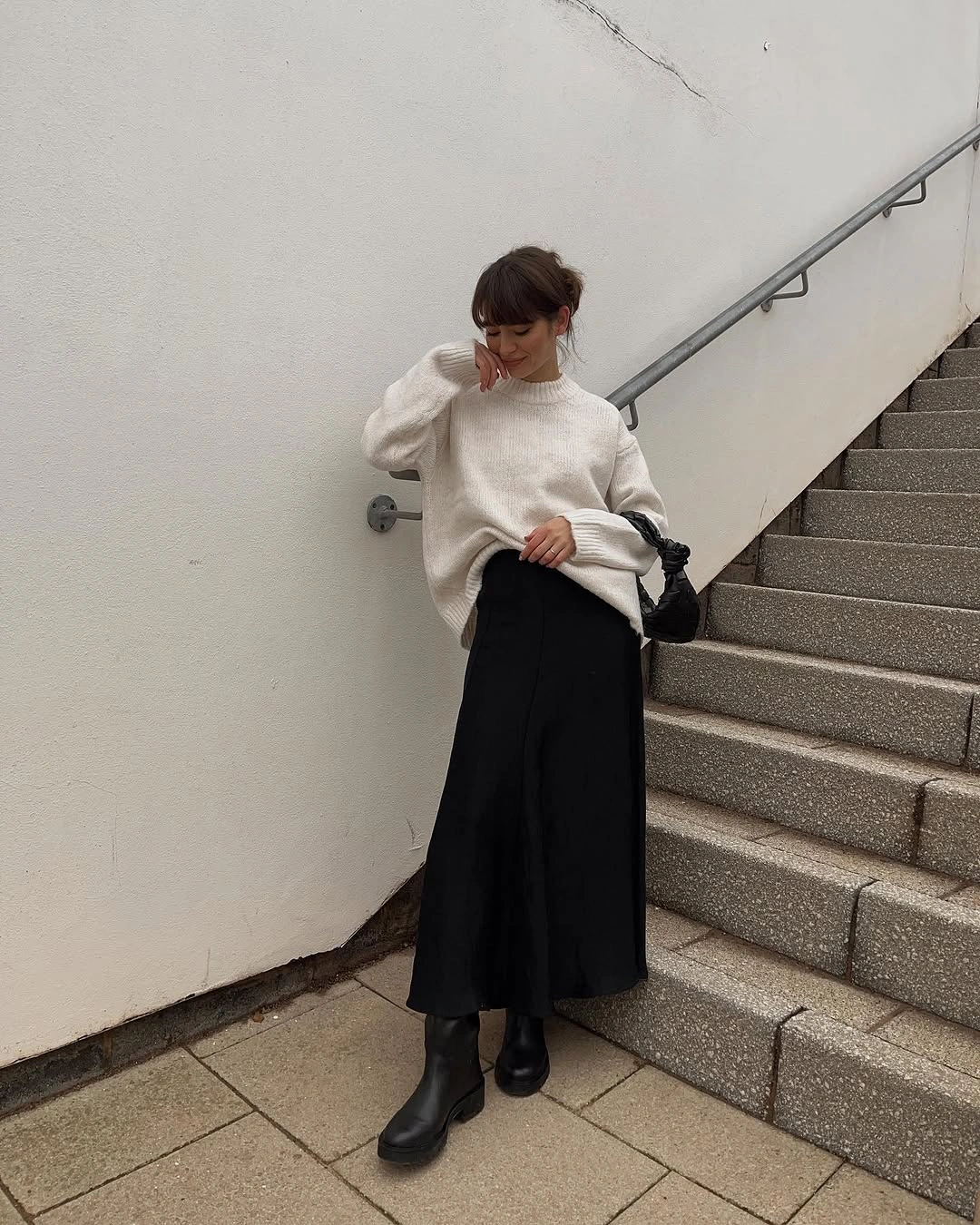 Ivory sweater with black A-line midi skirt and chunky ankle boots