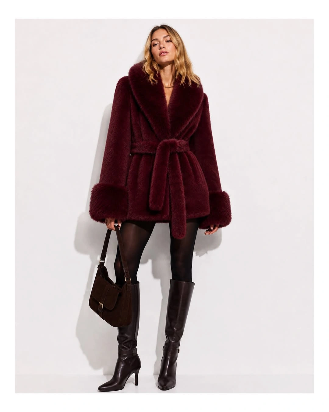Burgundy plush coat with black tights and tall pointed boots
