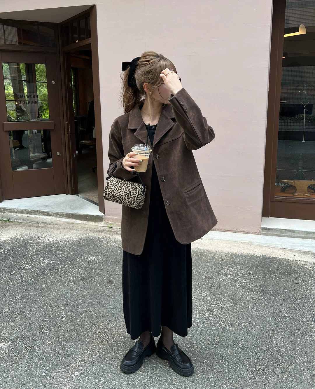Brown blazer over long black outfit with loafers and patterned shoulder bag