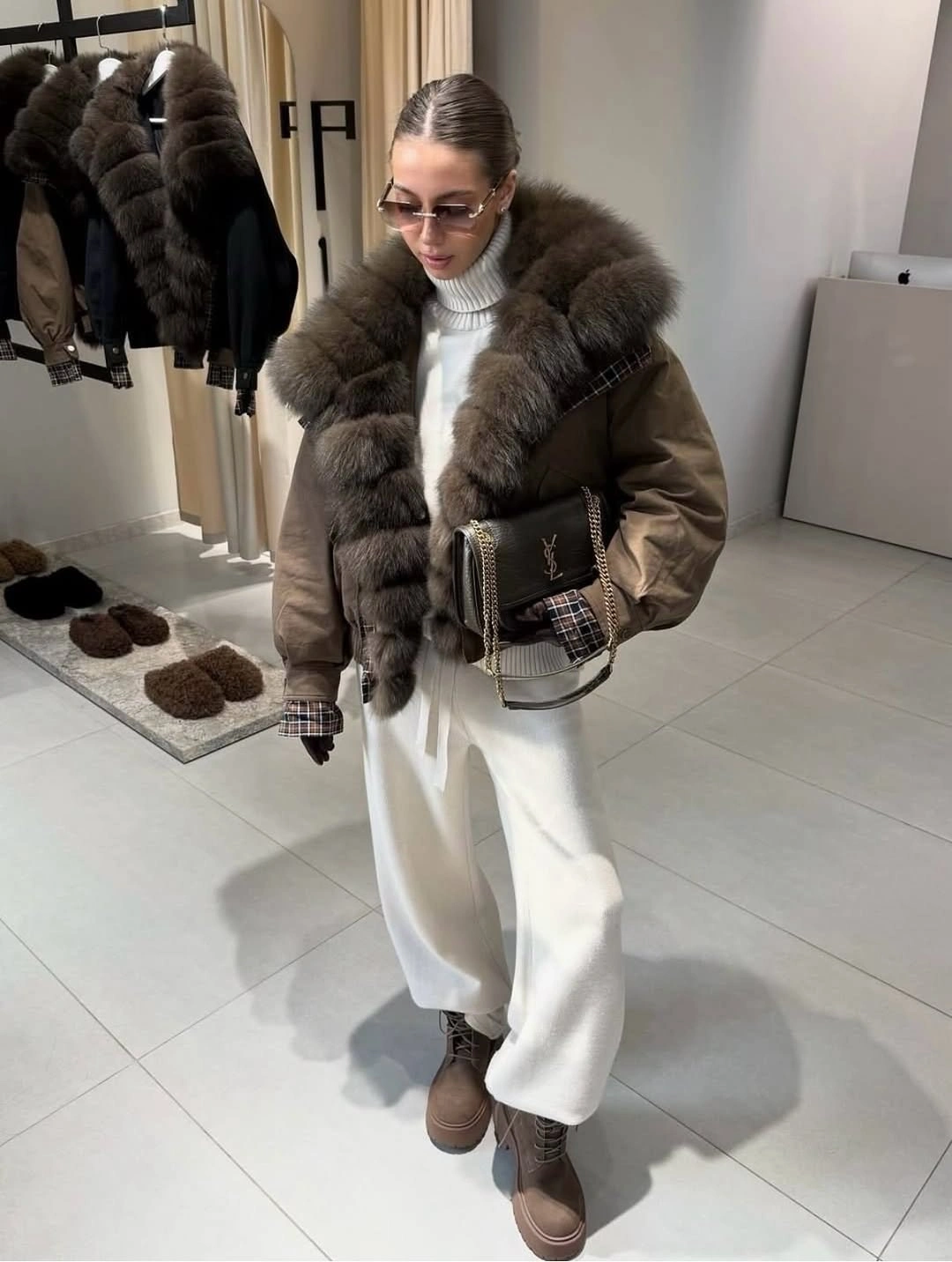 Brown jacket with fur-textured collar, white trousers, and brown platforms