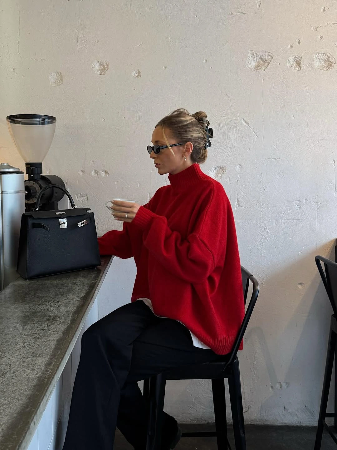 Bright red sweater over white shirt with wide black trousers