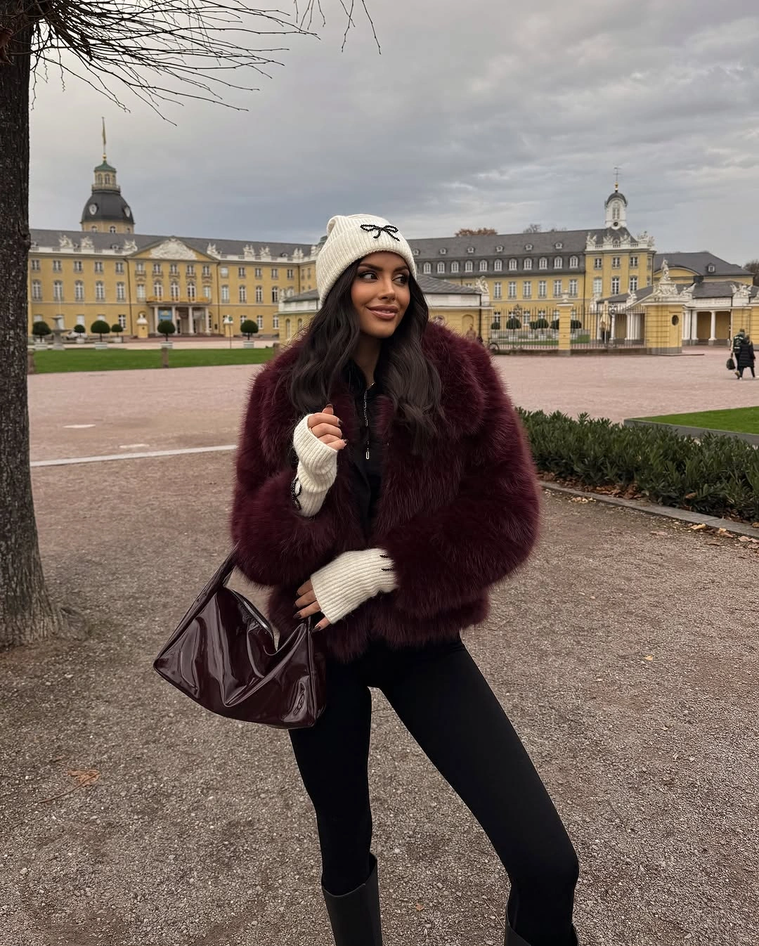Burgundy textured jacket black leggings white knit hat and dark boots