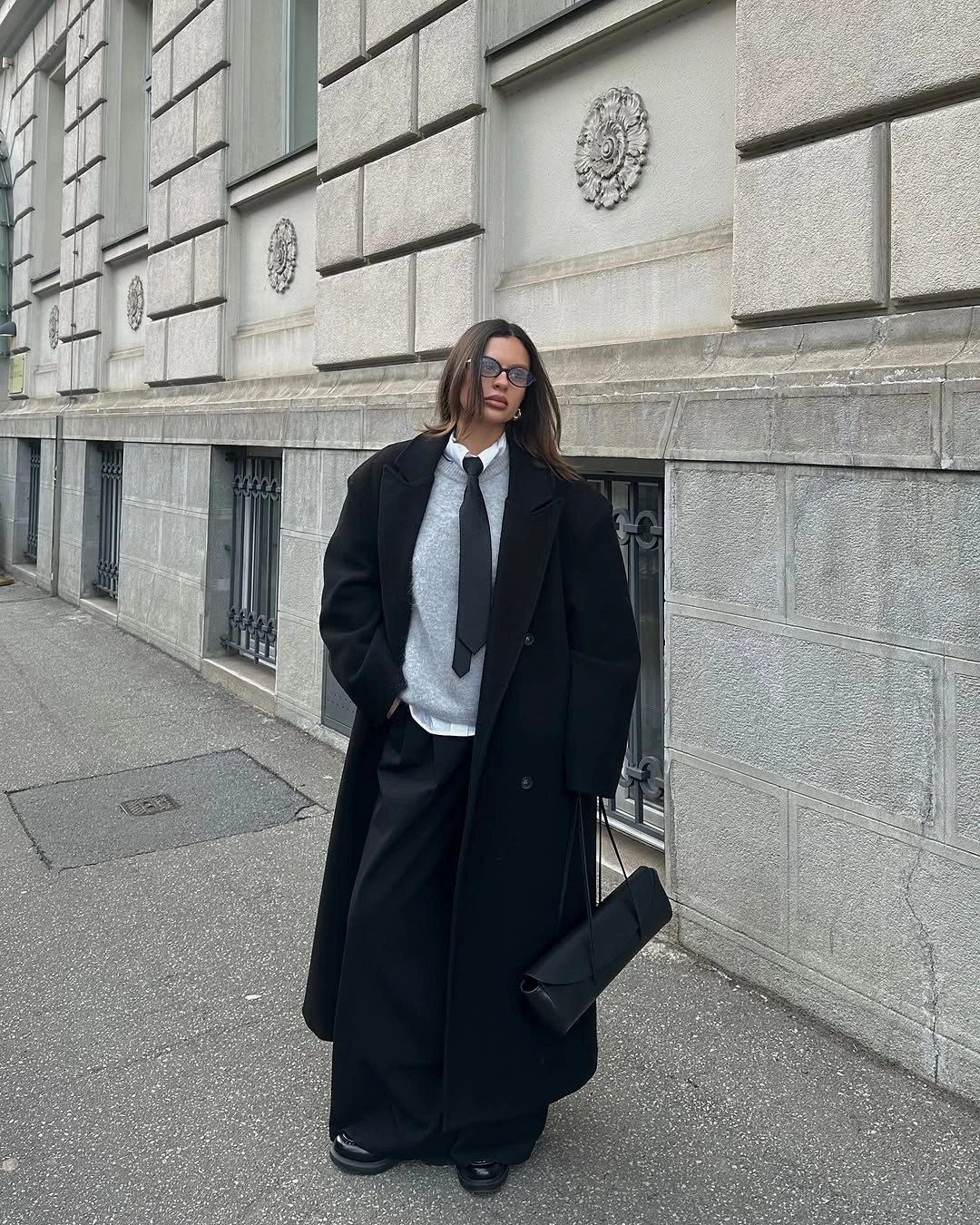 Long black coat wide black trousers white neckline detail and black bag