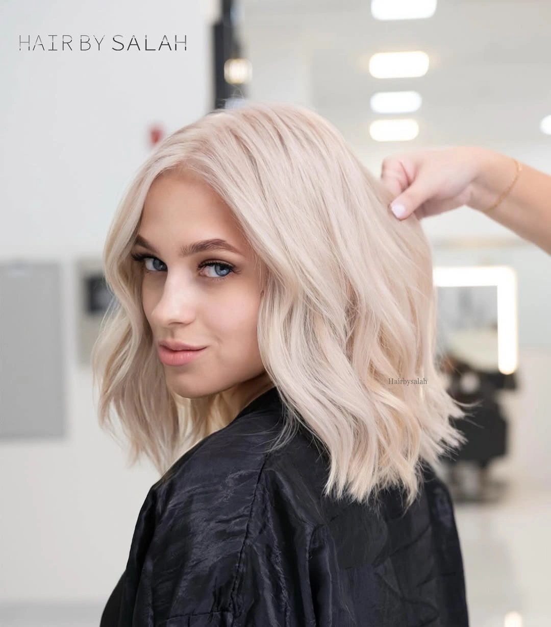 Shoulder-length blush pearl blonde lob with loose waves