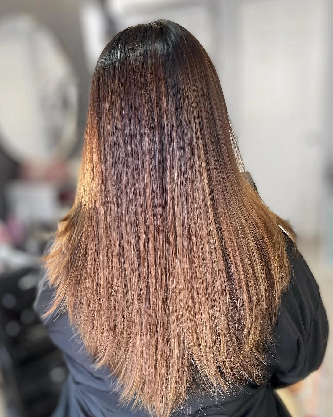 Long straight brunette hair with coppery light-brown lower lengths