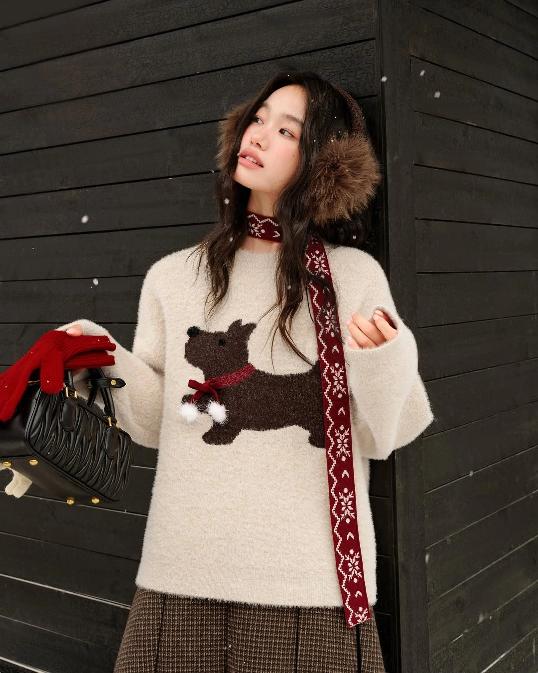 Cream motif sweater with red scarf, red gloves, checked lower layer, and black bag.
