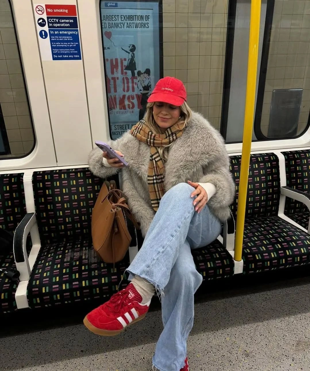 Shaggy grey jacket, plaid scarf, light blue jeans, red cap, and red sneakers.