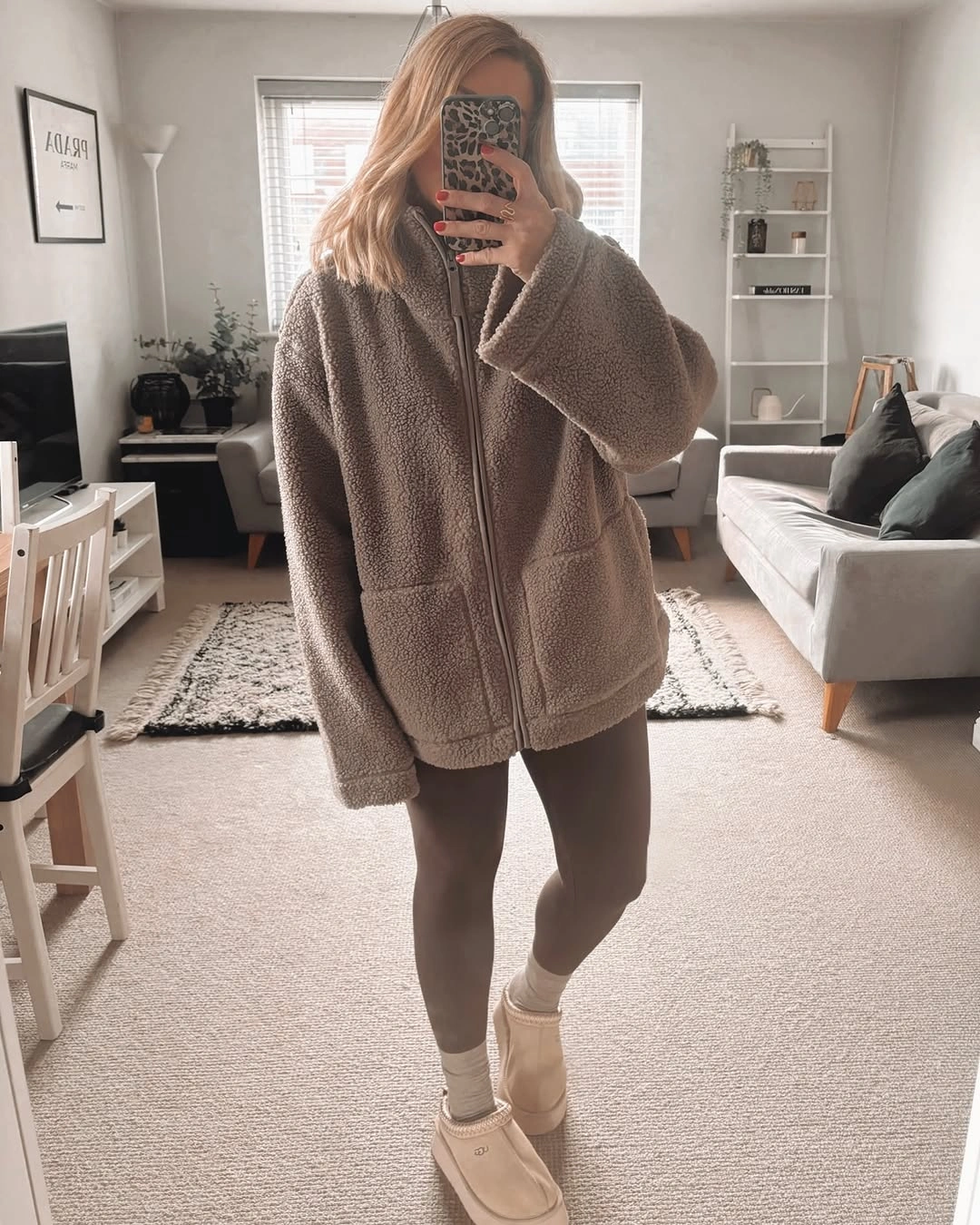 Short fuzzy taupe jacket, fitted taupe lower layers, light ribbed socks, and beige ankle boots.