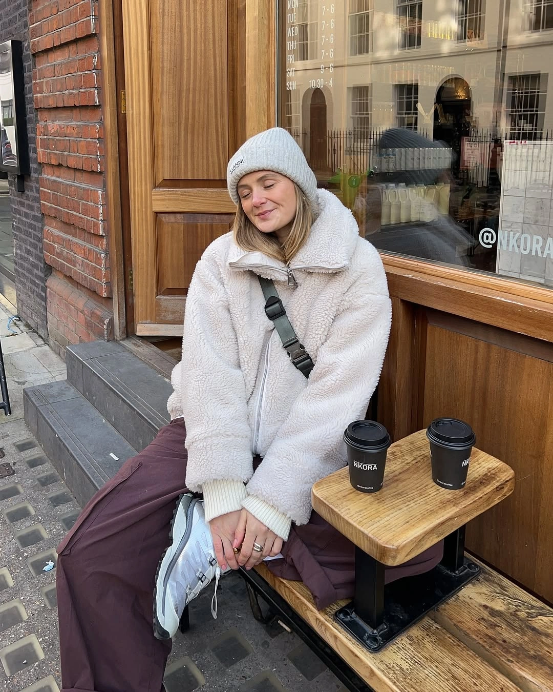 Cream jacket, gray beanie, burgundy pants, and light sneakers