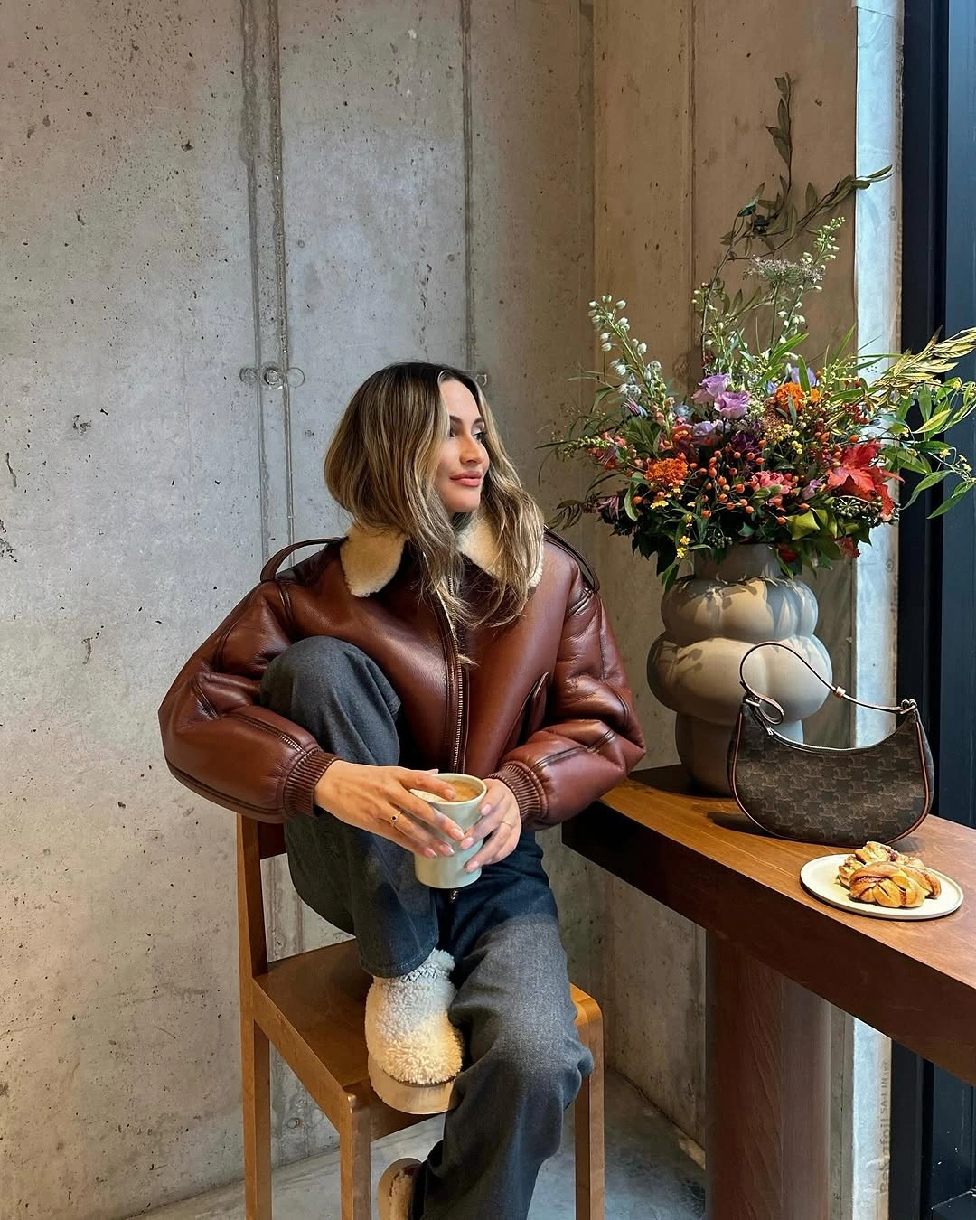 Glossy brown jacket, pale collar, dark jeans, fluffy boots