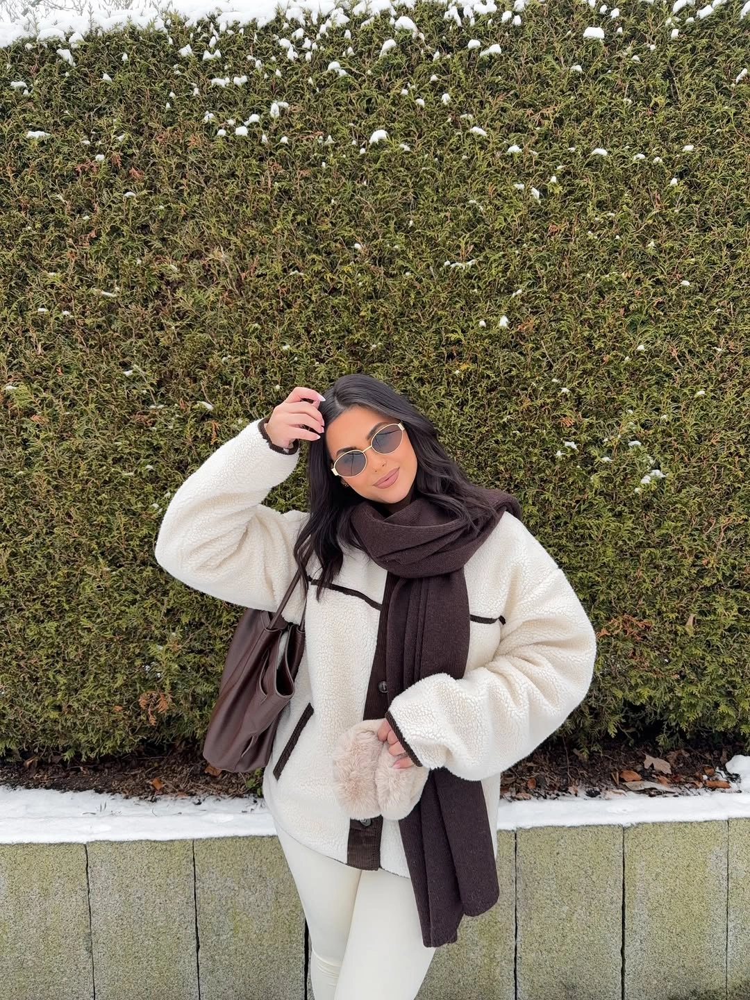 Cream jacket, white pants, dark scarf, brown shoulder bag