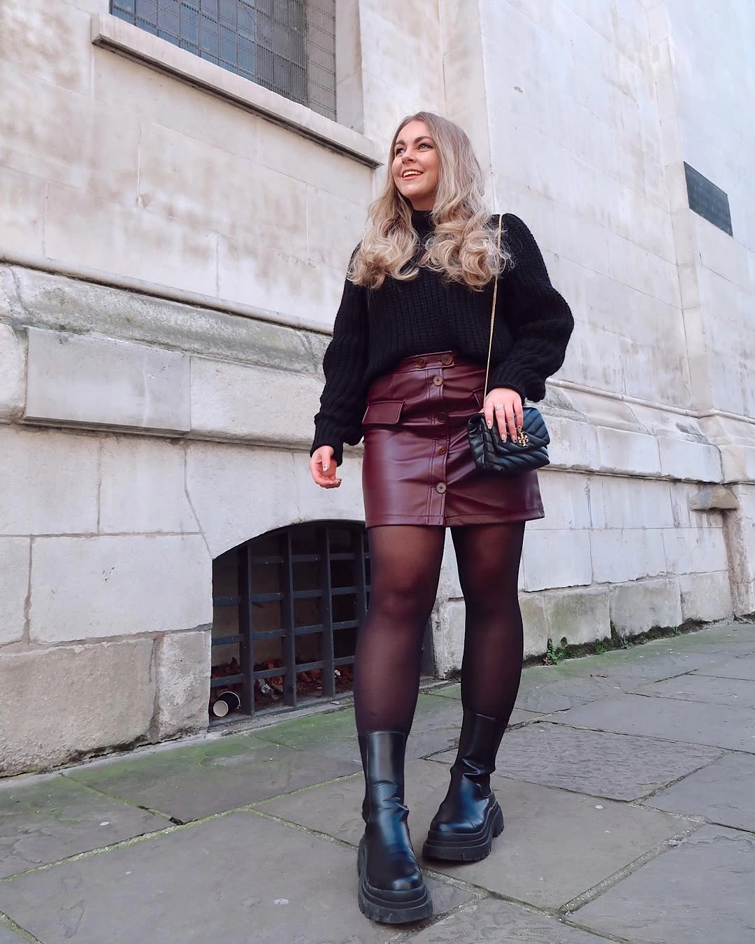 Black cardigan, burgundy mini skirt, tights, and boots