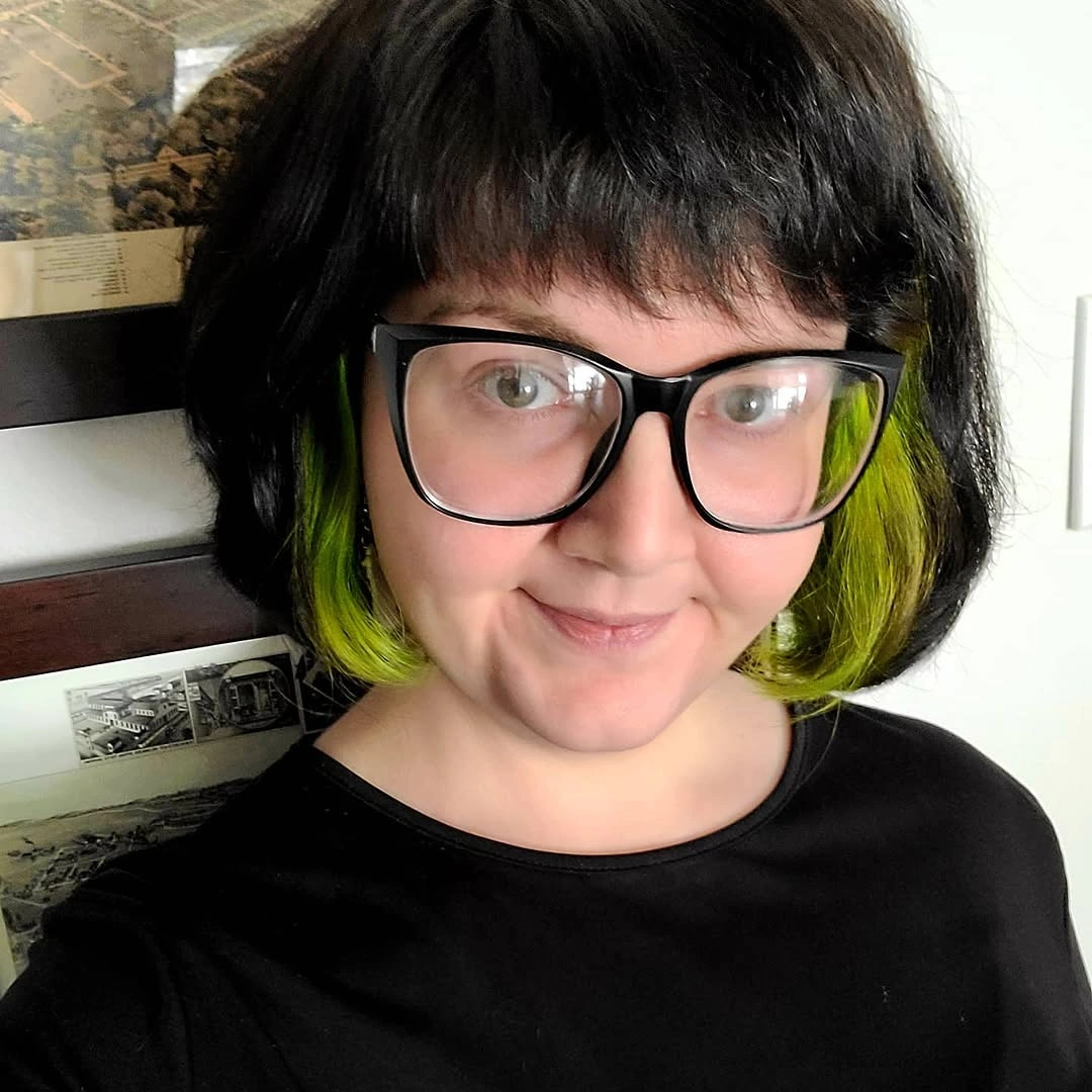 Short black bob with full bangs and green underlayer